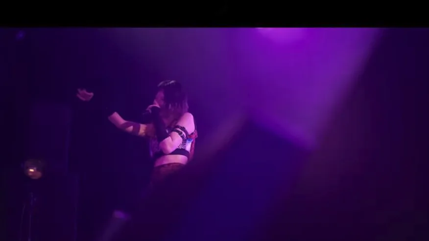 紫の照明に包まれたライブパフォーマンス