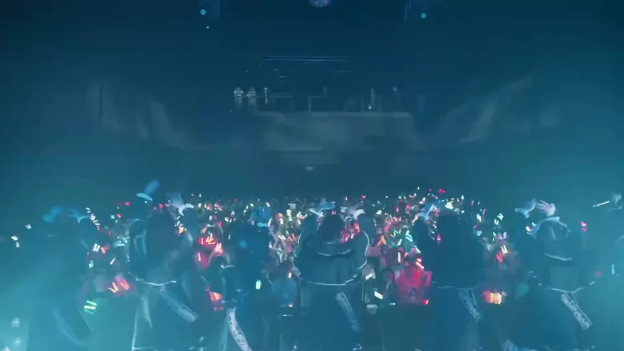 青い照明のステージを客席側から捉えたライブ風景