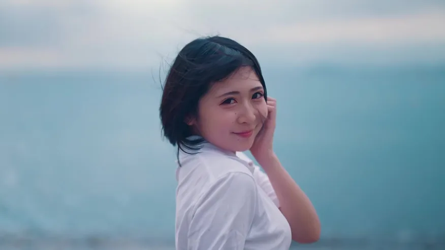 海辺でカメラを振り返る少女