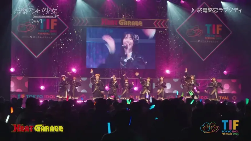 大型スクリーンとマゼンタの照明に彩られたライブ会場